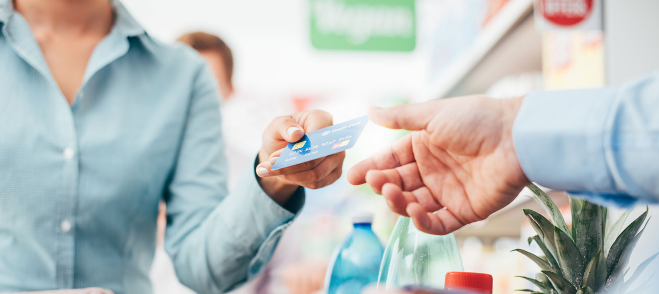 closeup of hand holding a credit card while making a store purchase