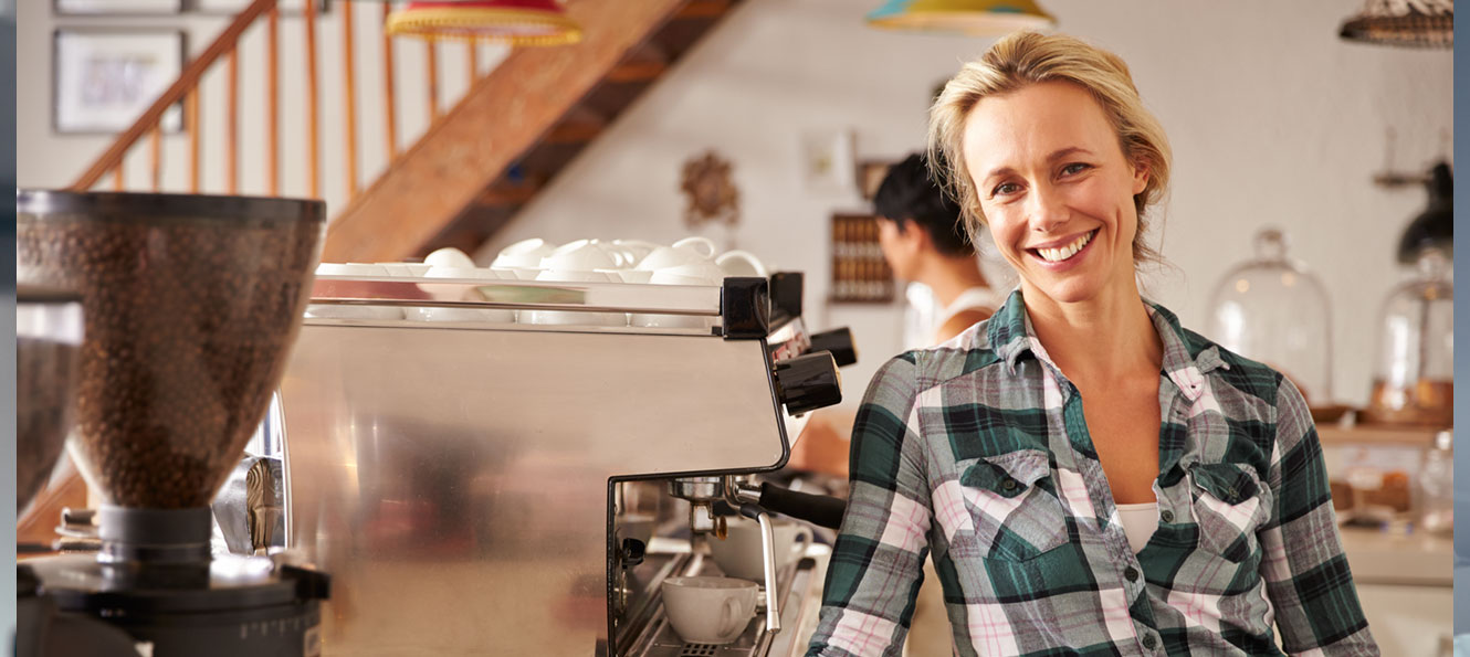 portrait of a business owner smiling in her coffee shop