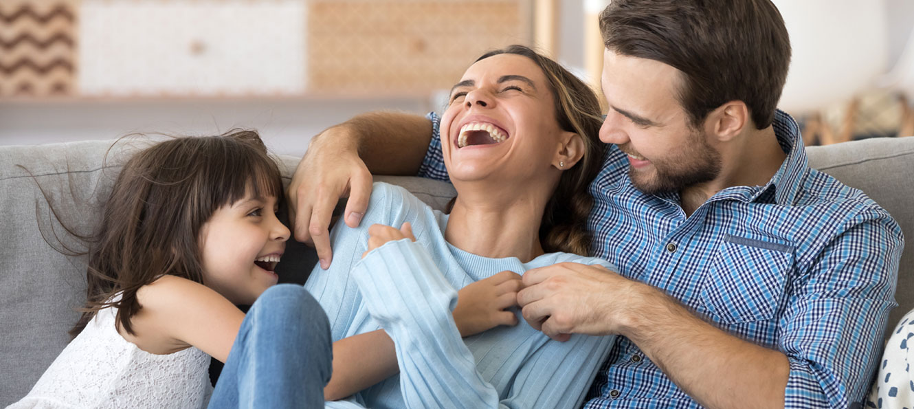 family of three smiling and enjoying their time together